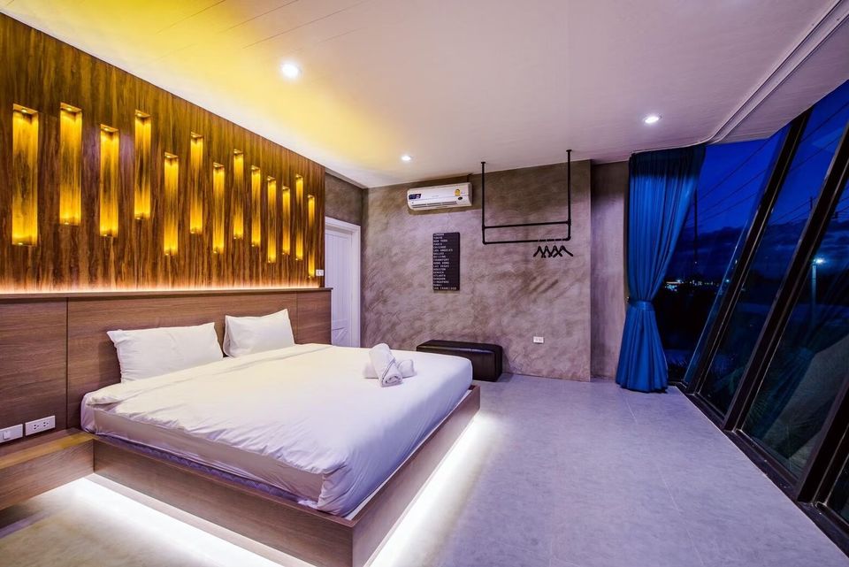 Modern king-size bed with under-bed lighting and unique wooden wall decor in Holiday Sunset Villa IV, Hua Hin.