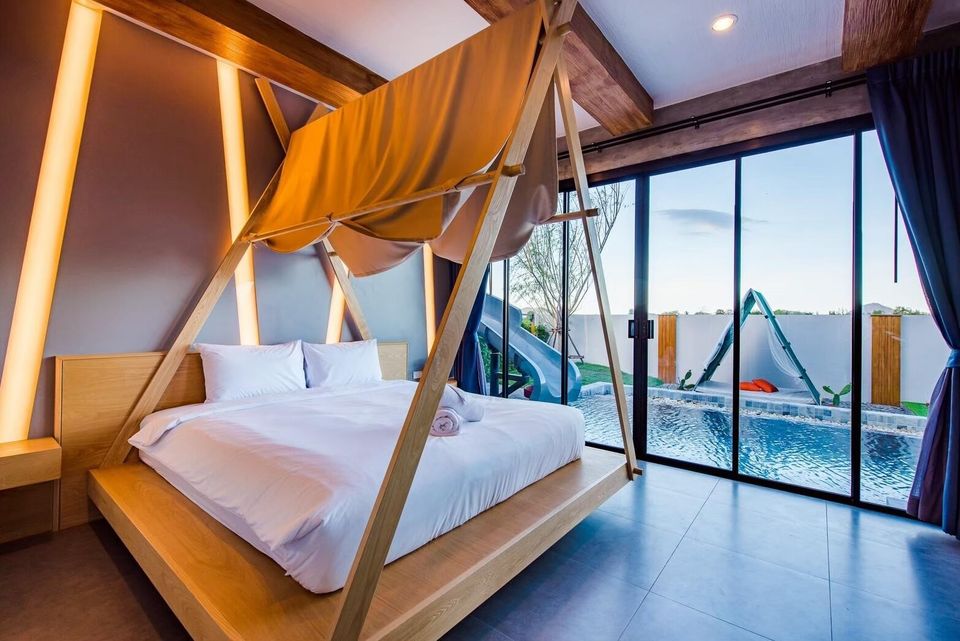 Unique tent-style bed in a bedroom at Holiday Sunset Villa IV, Hua Hin, with direct pool access and a water slide view.