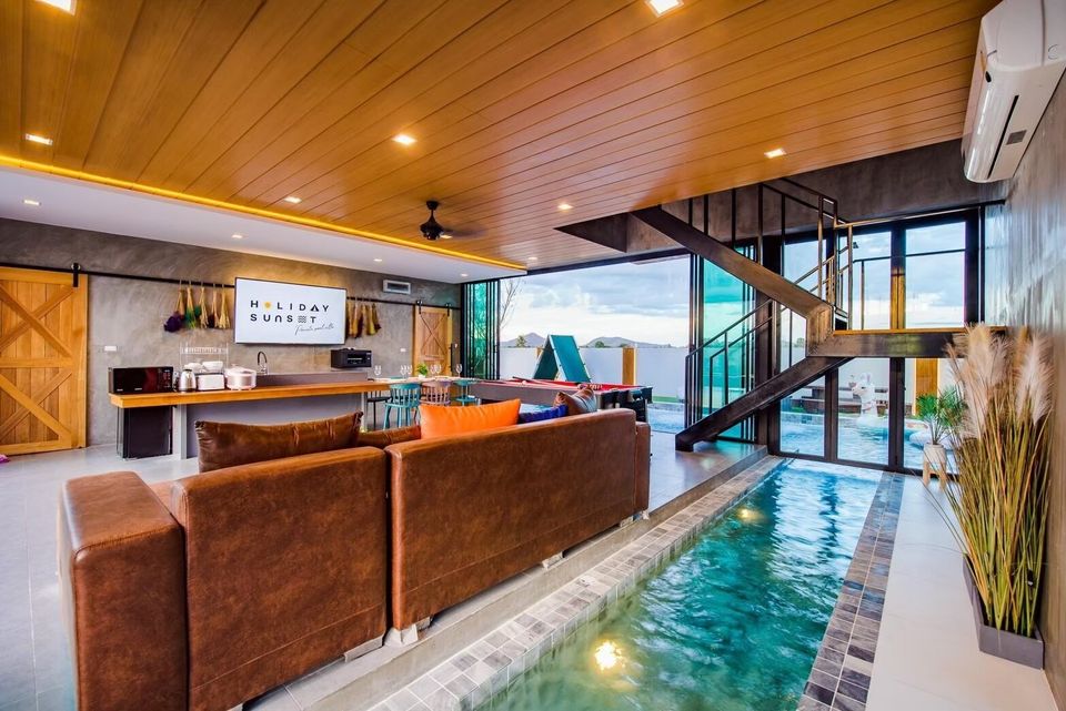 Unique indoor pool channel runs alongside the living area and stairs at Holiday Sunset Villa IV in Hua Hin, Thailand.