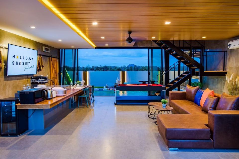 Spacious open-plan living area at Holiday Sunset Villa IV, Hua Hin, featuring a comfortable sofa, dining table, and pool table.