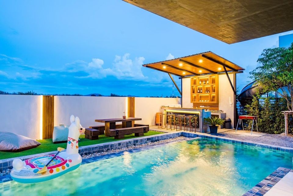 Holiday Sunset Villa IV in Hua Hin features a private pool with a swim-up bar, BBQ grill, and outdoor dining area.