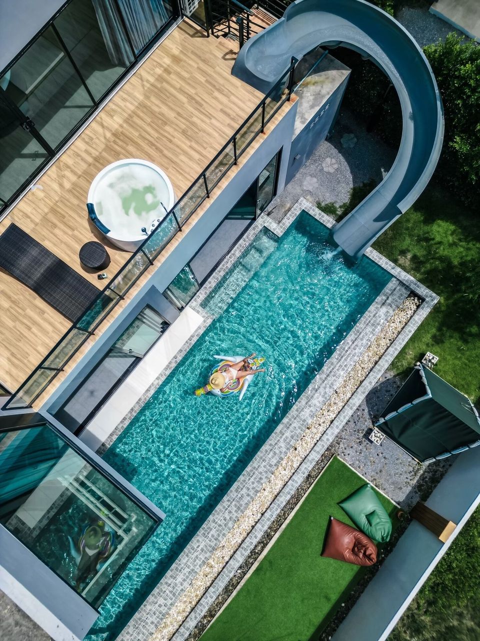 Aerial view of Holiday Sunset Villa IV in Hua Hin, featuring a swimming pool with a water slide, a jacuzzi, and a sun deck.