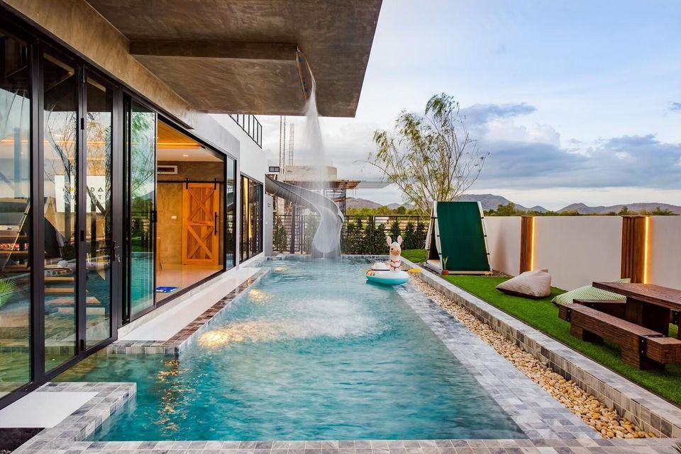 Holiday Sunset Villa IV in Hua Hin features a private pool with a fun water slide and a charming outdoor seating area.