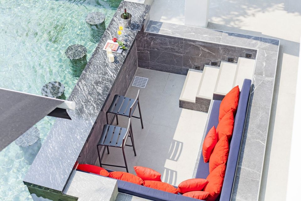 Overhead view of swim-up bar with stools in the pool at HI Classic Pool Villa V, Pattaya. Drinks and seating visible.