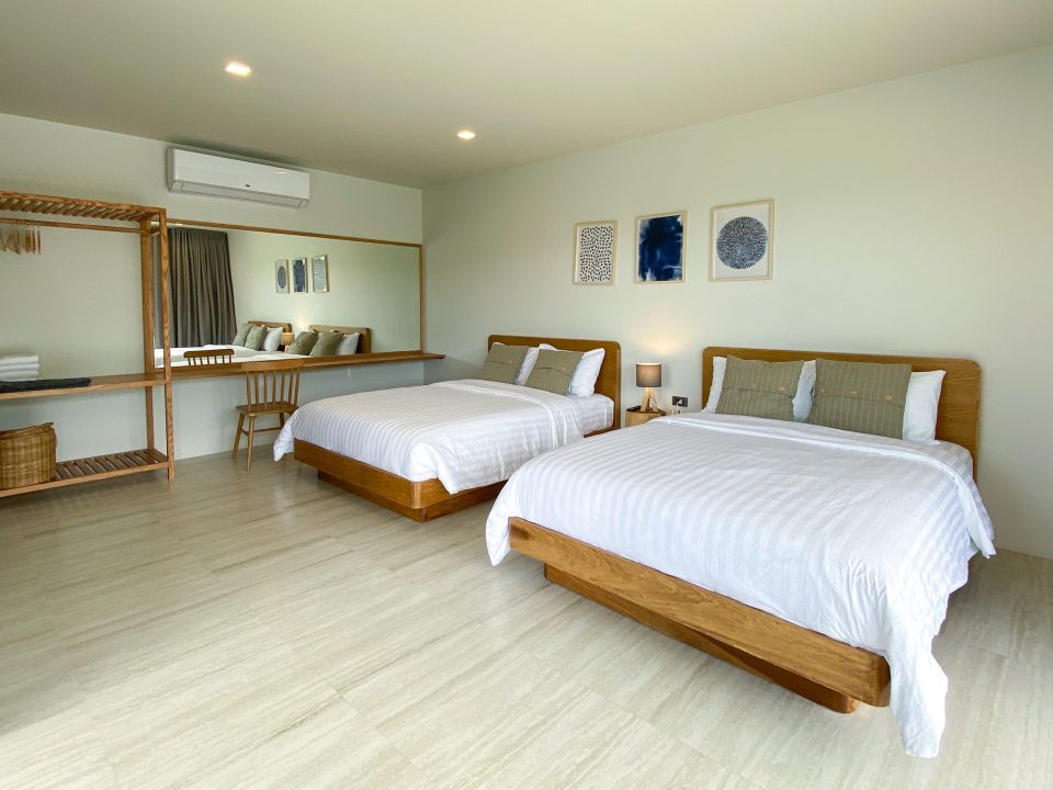 Bedroom with two twin beds at Kin Khaoyai V Pool Villa, หมูสี เขาใหญ่. Features wooden bed frames and modern artwork.