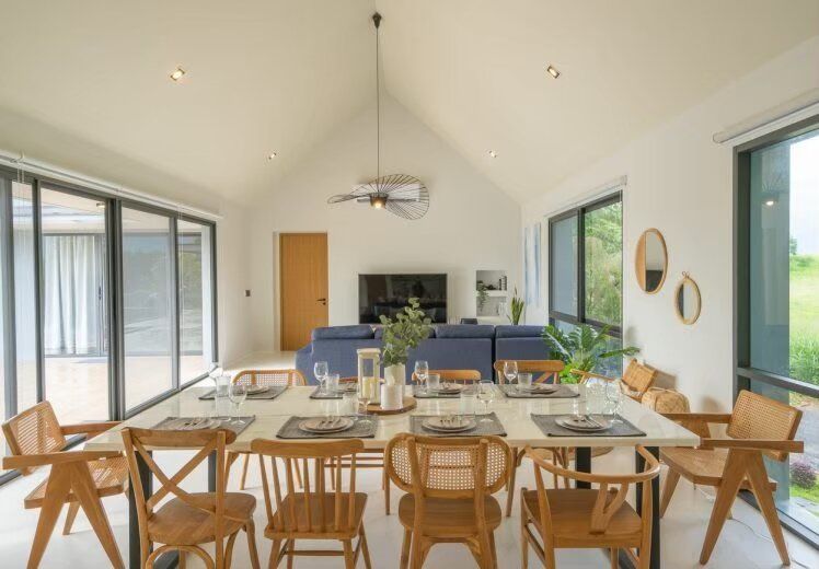 Spacious indoor dining area with a long table and wooden chairs, set for a meal at Kin Khaoyai V Pool Villa, Khao Yai.