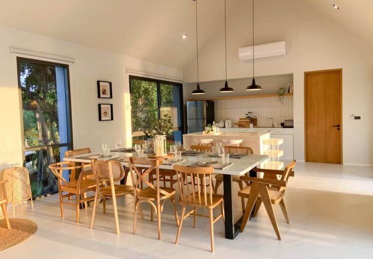 Spacious dining area with a large marble table and wooden chairs, perfect for family meals at Kin Khaoyai V Pool Villa, Khao Yai.