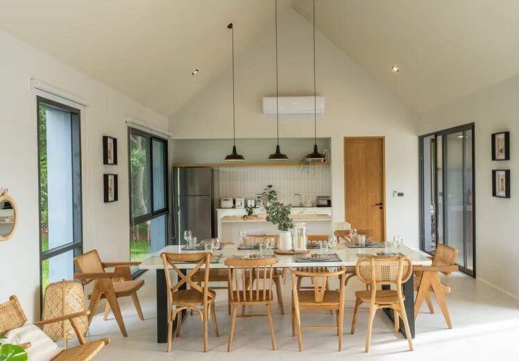 Spacious dining area with a long modern wooden table and chairs, perfect for family meals at Kin Khaoyai V Pool Villa.