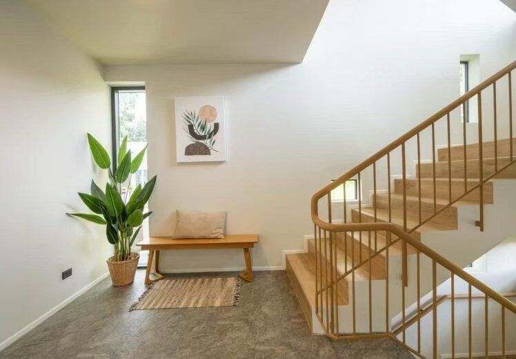 Modern wooden staircase and landing area with a bench and plant at Kin Khaoyai V Pool Villa, Khao Yai.