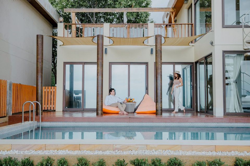 Marine Pran II pool villa poolside view in เขาสามร้อยยอด ปราณฯ, Thailand. Couple relaxing on beanbags.