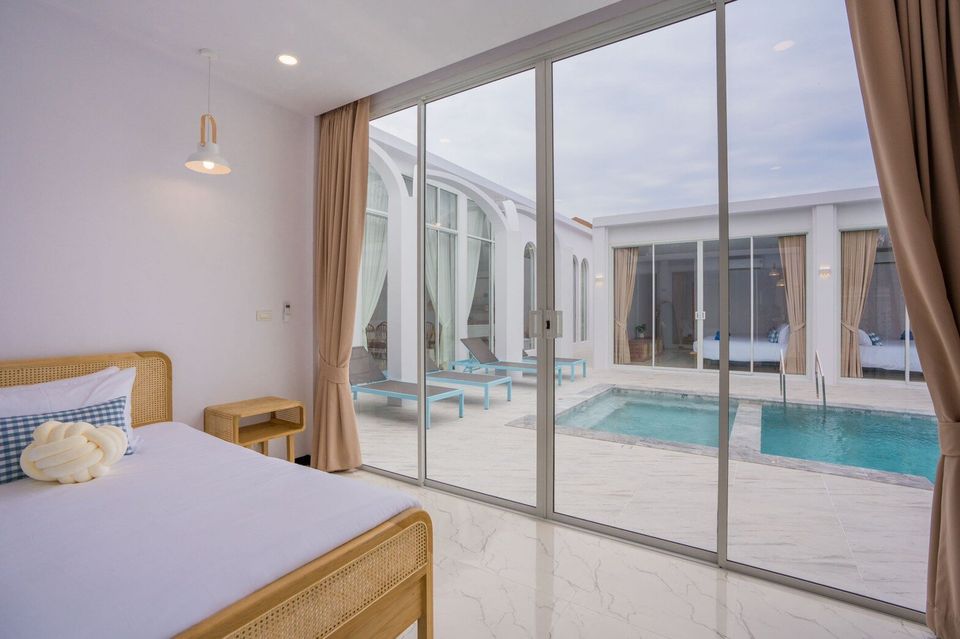 Bedroom with a rattan bed and direct pool access at Miami Beach VI Pool Villa, Cha-Am. Enjoy pool views from bed.