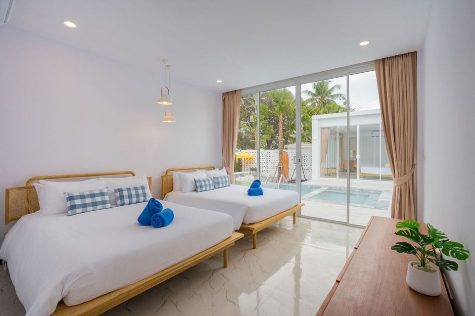 Bright bedroom with two beds, blue accents, and direct pool access at Miami Beach VI Pool Villa, Cha-Am.