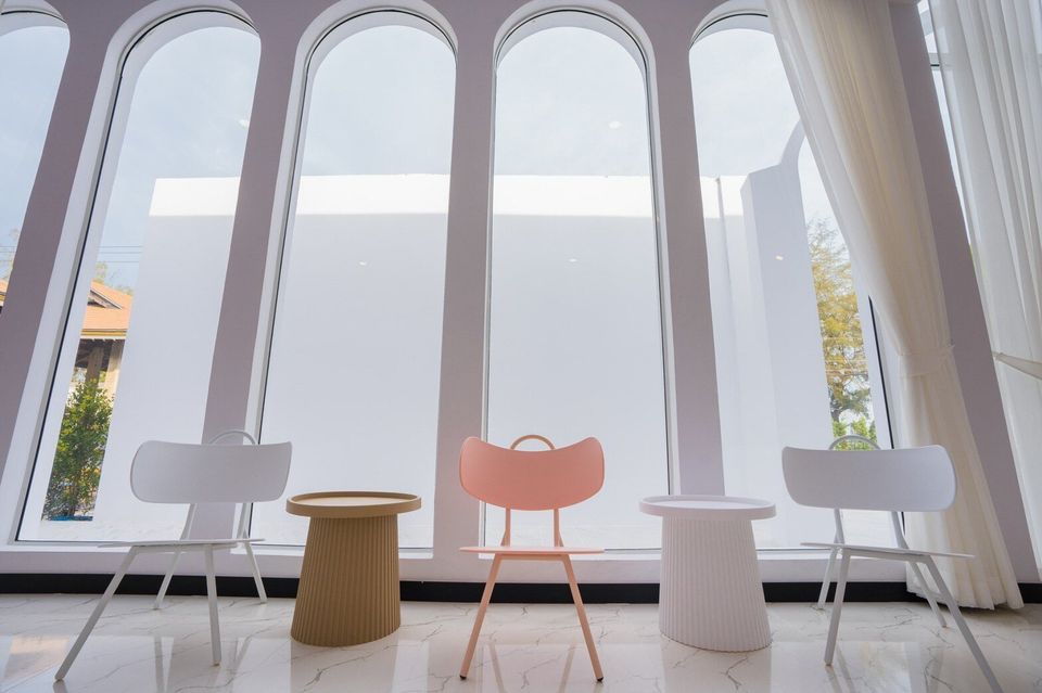 Modern seating area with arched windows and stylish chairs at Miami Beach VI Pool Villa, Cha-Am.