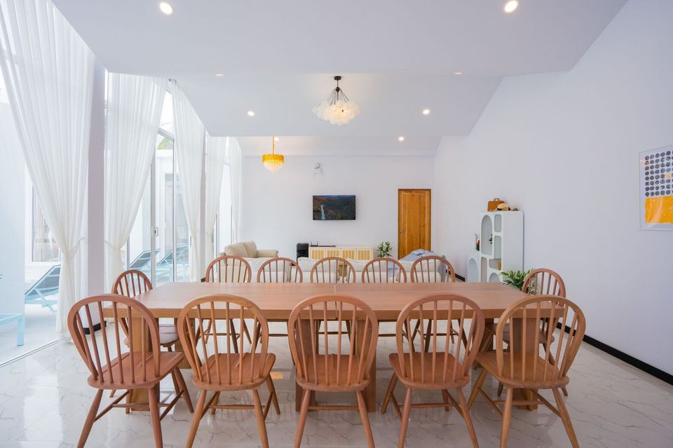 Spacious dining area with a long wooden table and chairs, perfect for group meals at Miami Beach VI Pool Villa, Cha-Am.