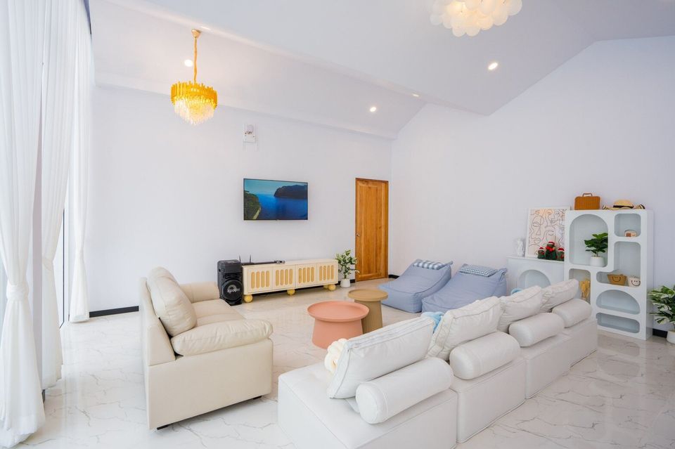 Bright living room at Miami Beach VI Pool Villa, Cha-Am, with white sofas, bean bags, TV, and modern decor.