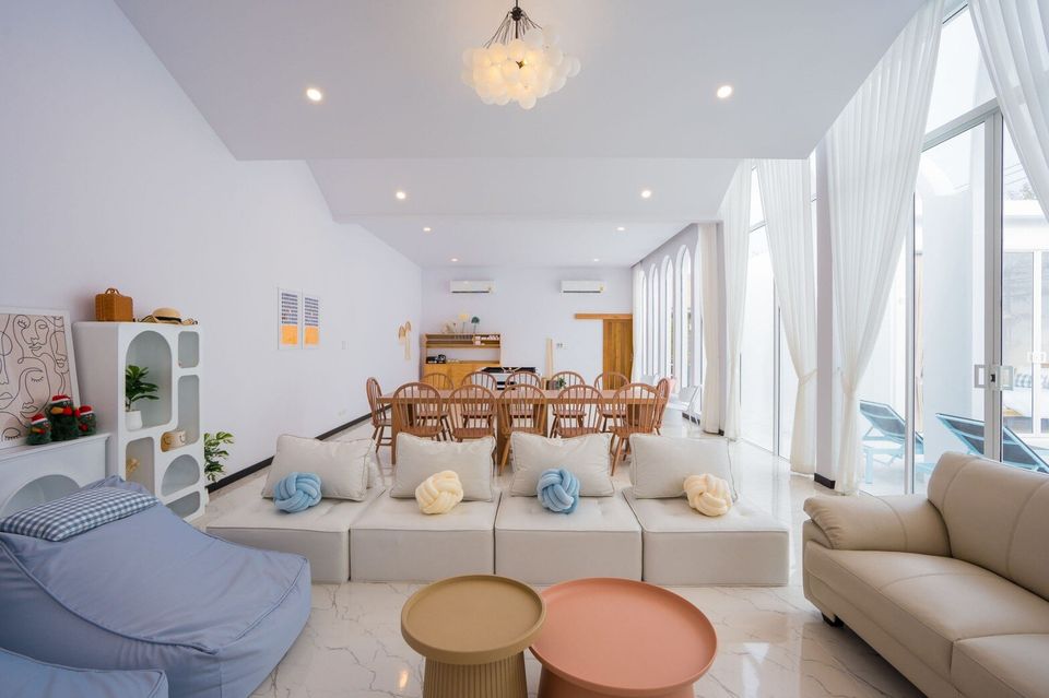 Spacious open-plan living and dining area at Miami Beach VI Pool Villa in Cha-Am, featuring modern seating and large windows.