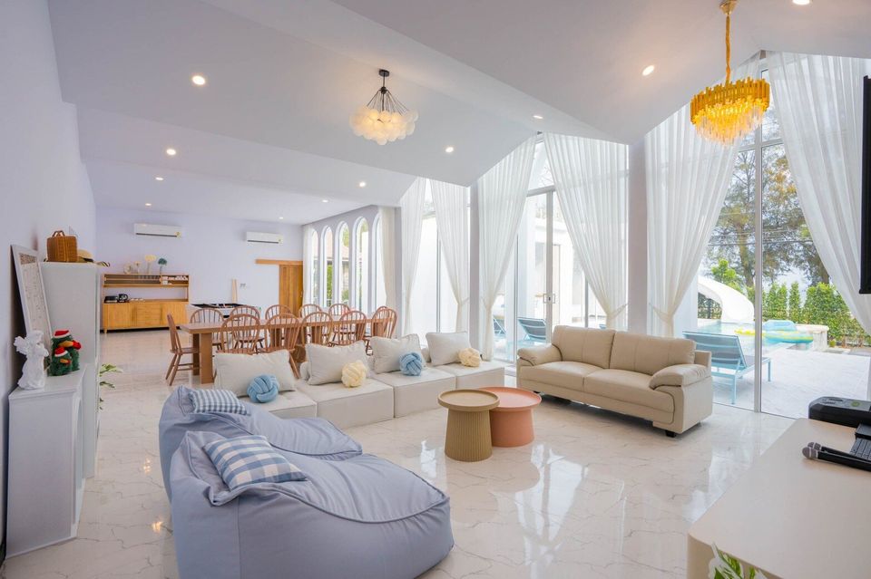 Spacious open-plan living and dining area at Miami Beach VI Pool Villa, Cha-Am, with modern sofas and pool views.