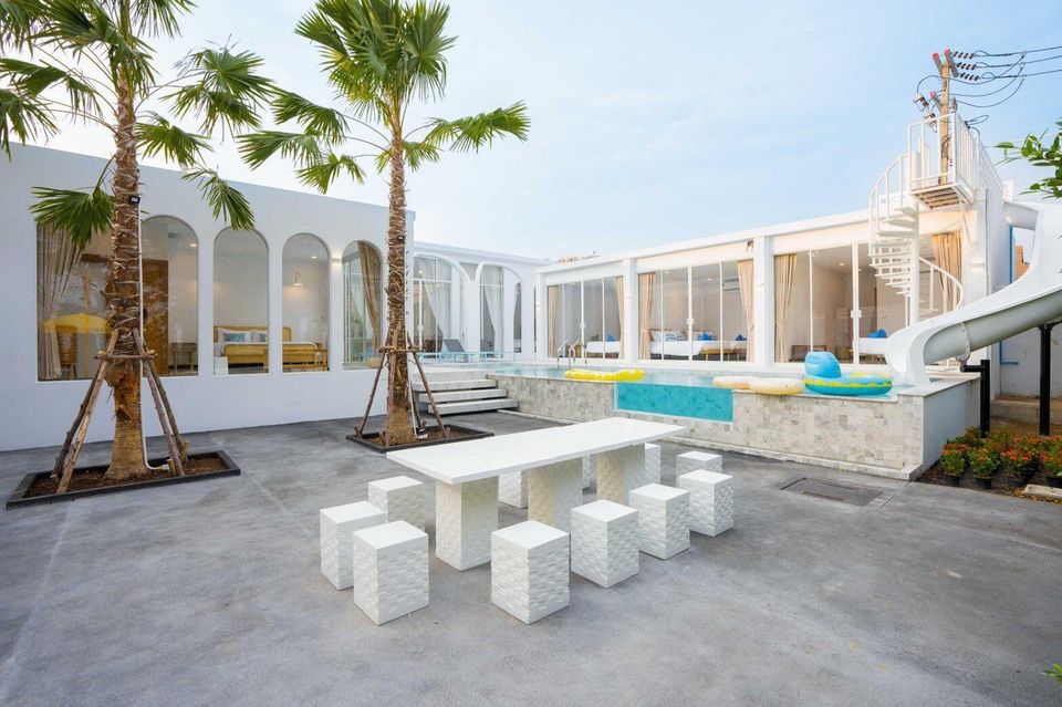 Miami Beach VI Pool Villa in Cha-Am features a private pool with a water slide, outdoor dining area, and palm trees.