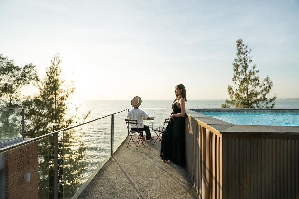 Ocean view terrace with pool at Pink Sand Beachfront Villa, บางละมุง พัทยาเหนือ. Couple relaxing by the pool.