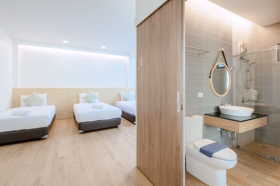 Bedroom and bathroom view at Pool Lay AI Pool Villa, Na Jomtien, Pattaya. Features three beds and modern bathroom.