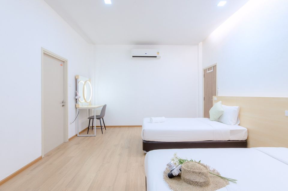 Bright bedroom with twin beds and vanity at Pool Lay AI Pool Villa, Na Jomtien, Pattaya, Thailand.