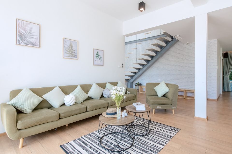 Bright living room with modern staircase at Pool Lay AI Pool Villa, Na Jomtien, Pattaya.
