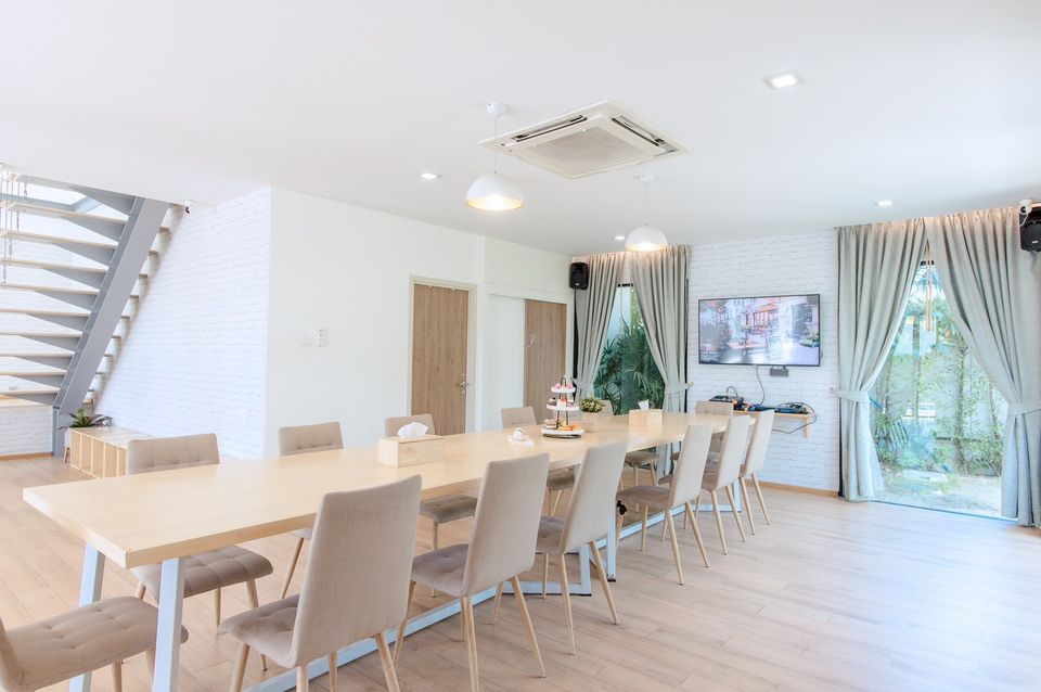 Bright dining room at Pool Lay AI Pool Villa, Na Jomtien, Pattaya. Long wooden table with seating for many guests.