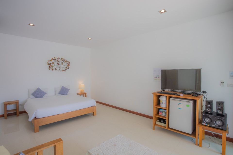 Bright bedroom with TV and mini fridge at Proud I Pool Villa, Hua Hin, Thailand.