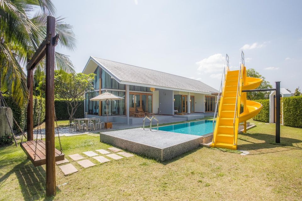 Bright yellow waterslide next to the pool at Proud III Pool Villa, Hua Hin. Fun for the whole family!