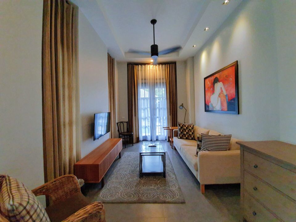 Living room with TV and sofa at Sala Haven Nine Pool Villa, South Pattaya, Thailand.