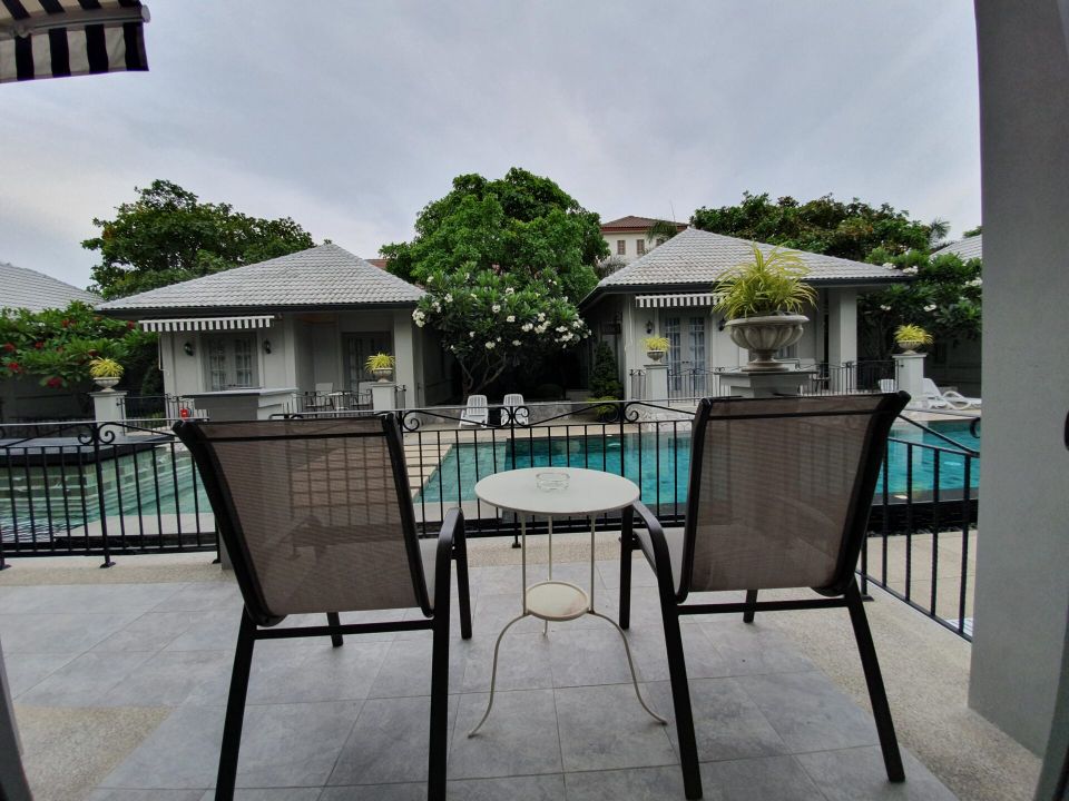 Balcony view of the pool at Sala Haven Nine Pool Villa, South Pattaya. Relax on the balcony overlooking the pool.