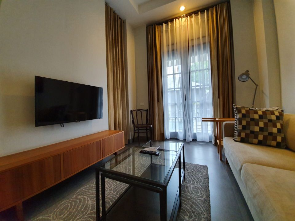 Living room with TV and sofa at Sala Haven Nine Pool Villa, South Pattaya, Thailand.