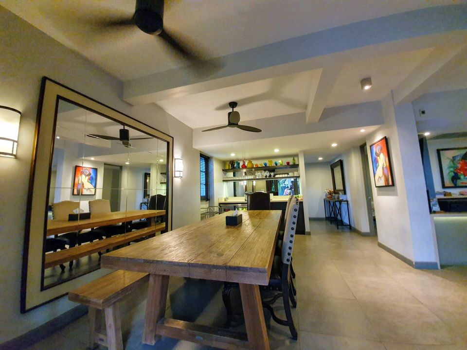 Dining area with rustic wooden table and bench at Sala Haven Nine Pool Villa, South Pattaya, Thailand.
