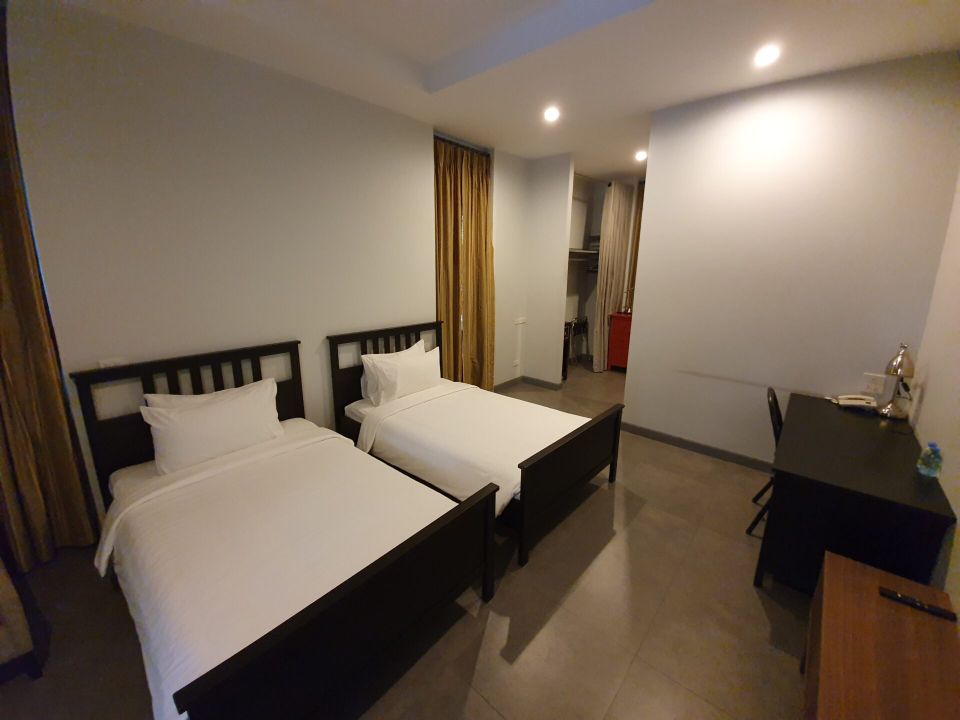 Bedroom with twin beds and desk at Sala Haven Nine Pool Villa, South Pattaya, Thailand.
