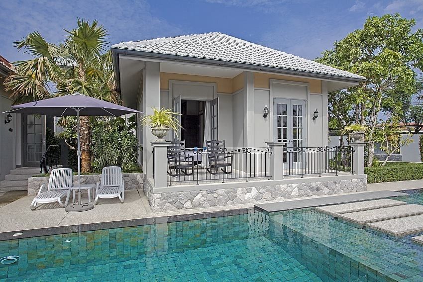 Pool view of Sala Haven Nine Pool Villa in South Pattaya, Thailand. Villa with patio, chairs, and pool access.