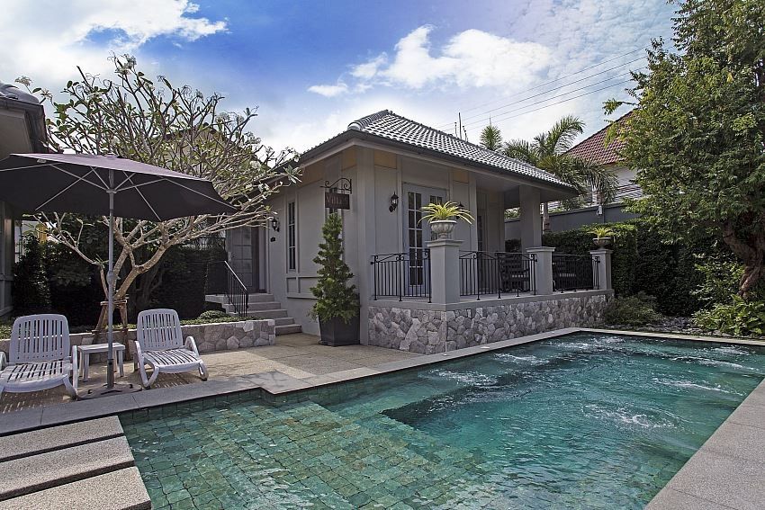 Poolside view of Sala Haven Nine Pool Villa in South Pattaya, Thailand. Features pool, lounge chairs, and villa exterior.