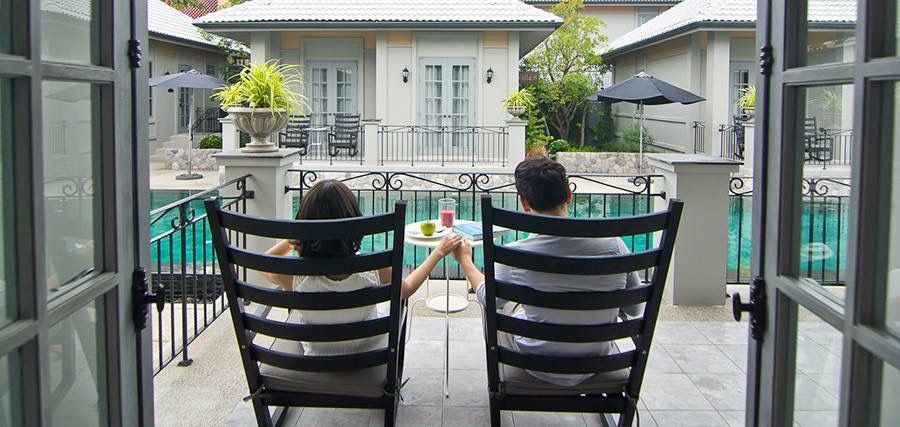 Couple relaxing by the pool at Sala Haven Nine Pool Villa, South Pattaya. Enjoying drinks and the view.