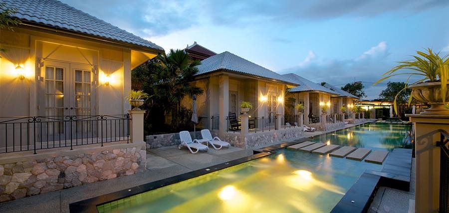 Evening view of the pool at Sala Haven Nine Pool Villa, South Pattaya. Walkway stones across the pool.