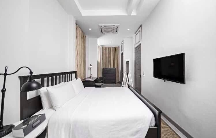 Bright bedroom with white linens at Sala Haven Nine Pool Villa, South Pattaya, Thailand.