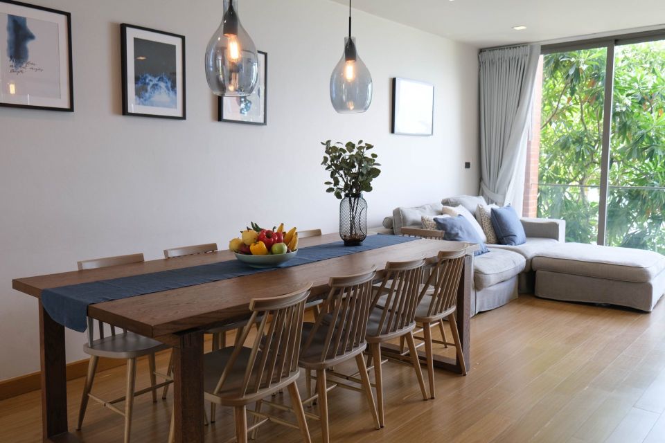 Dining area with wooden table and chairs at Sand Beachfront Pool Villa III, Pattaya. Fruit bowl centerpiece.