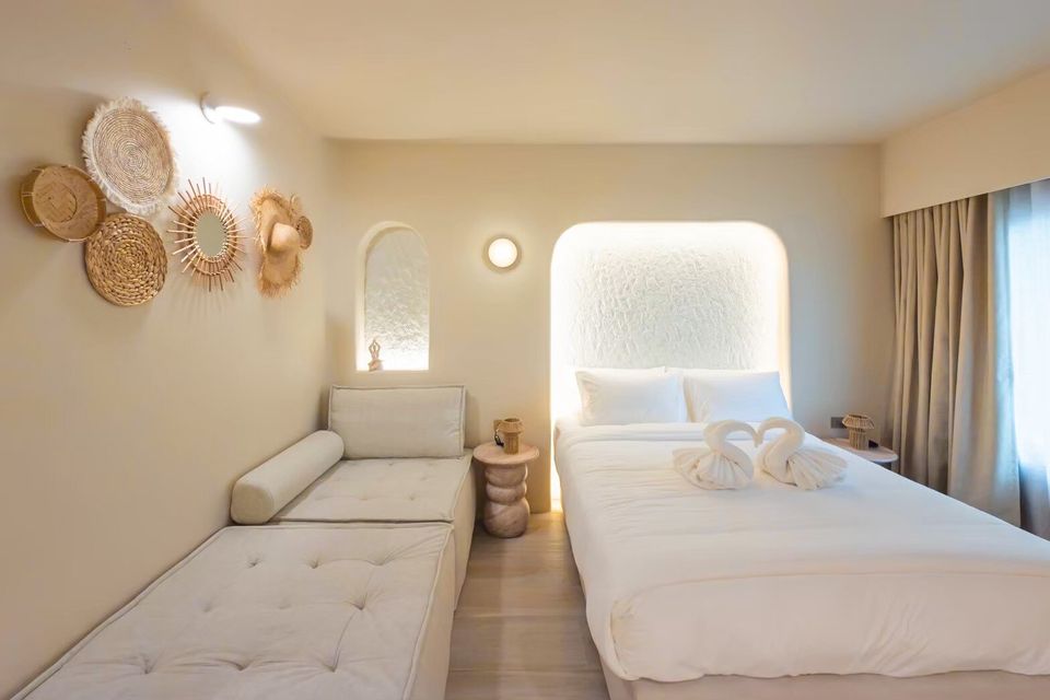 Bright bedroom at Sand Moment VI Pool Villa, Rayong, featuring a king-size bed, daybed, and boho-chic wall decor.