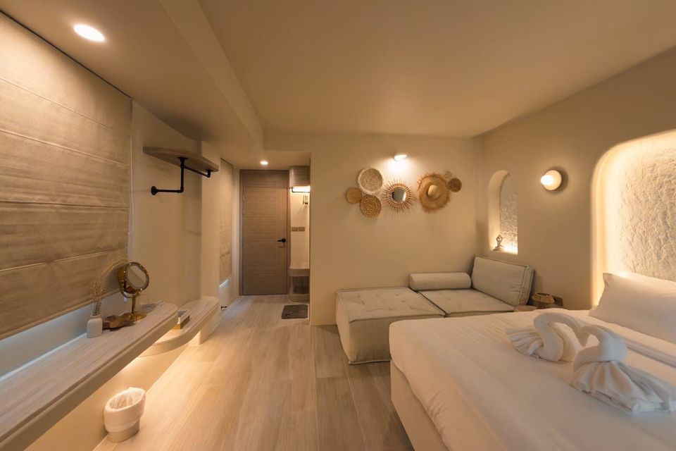 Cozy king-size bed with swan towel art and a comfortable sofa in a bedroom at Sand Moment VI Pool Villa, Rayong.