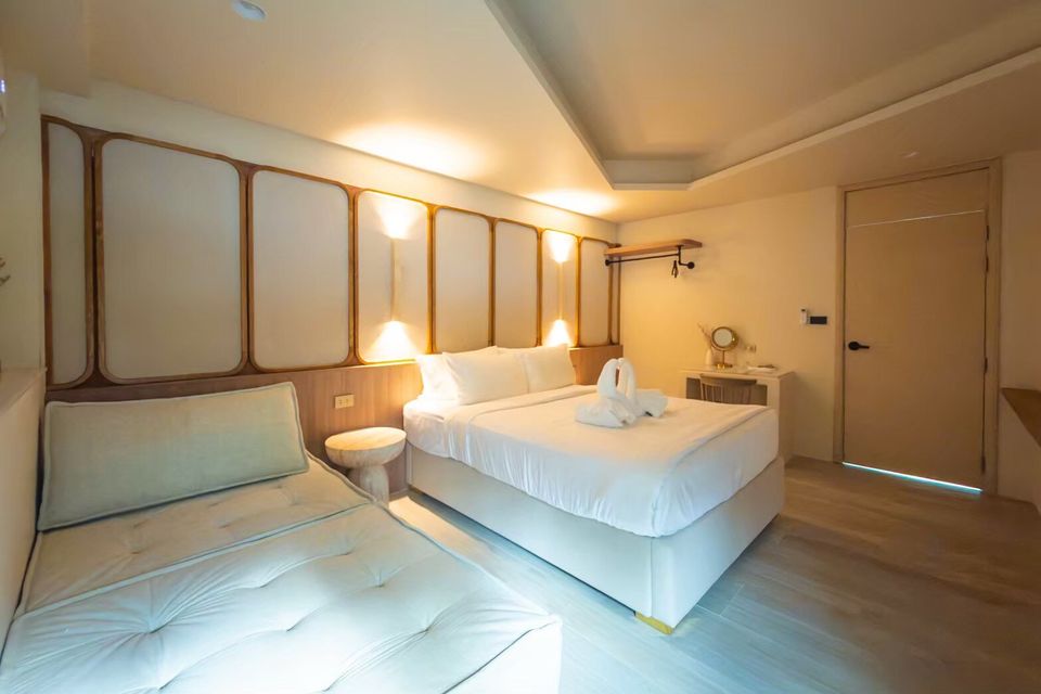 Bright bedroom at Sand Moment VI Pool Villa, Rayong, featuring a comfortable king-size bed and a cozy daybed.