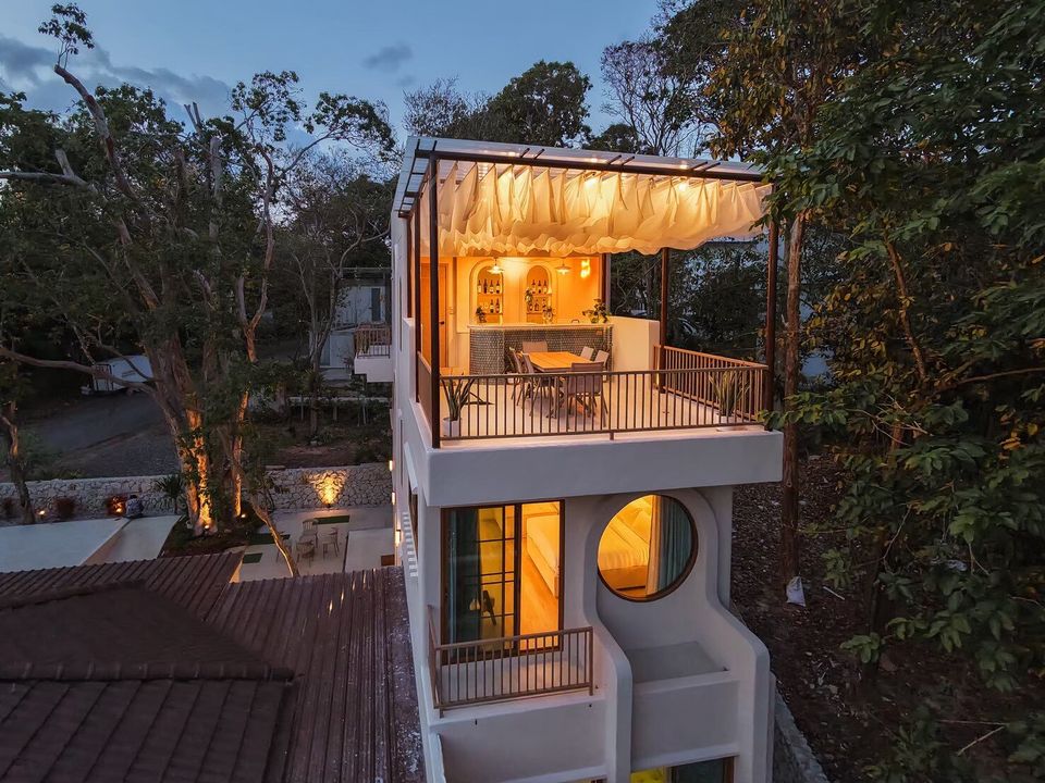 Aerial view of Sand Moment VI Pool Villa in Rayong at dusk, showcasing its unique rooftop bar and balcony.