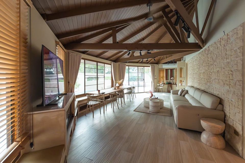 Spacious open-plan living and dining area with vaulted wooden ceiling at Sand Moment VI Pool Villa, Rayong. Light decor.