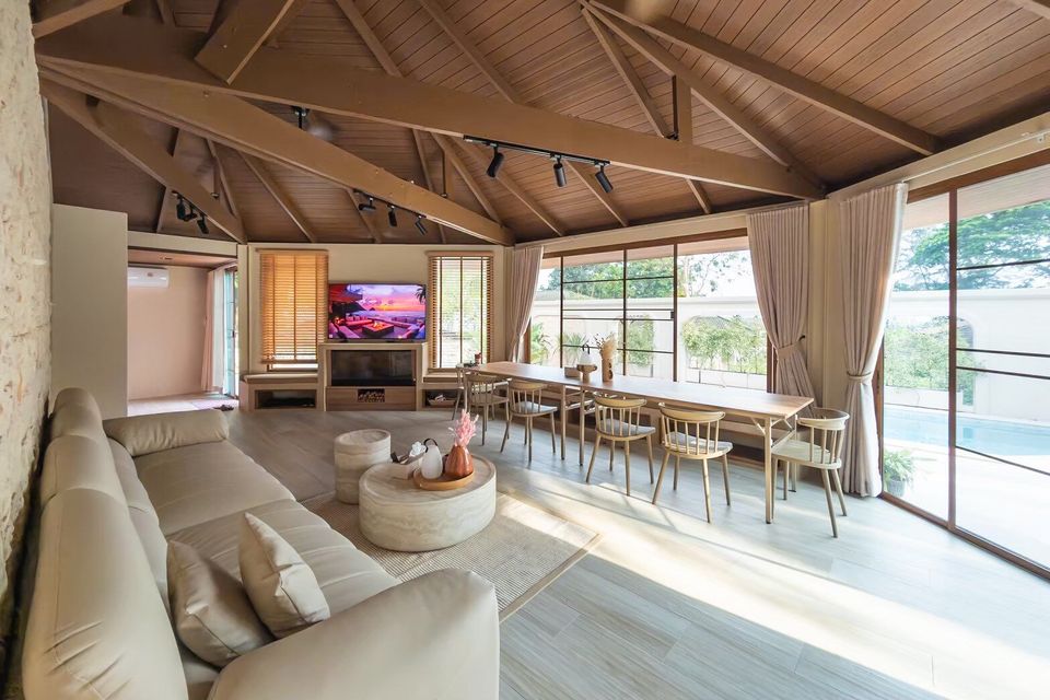 Spacious open-plan living and dining area at Sand Moment VI Pool Villa, Rayong, with large windows overlooking the pool.