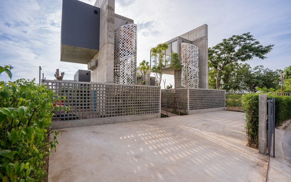 Exterior view of Sea Fan IV Beachfront Pool Villa near Huahin airport, showing modern concrete design and gated entrance.