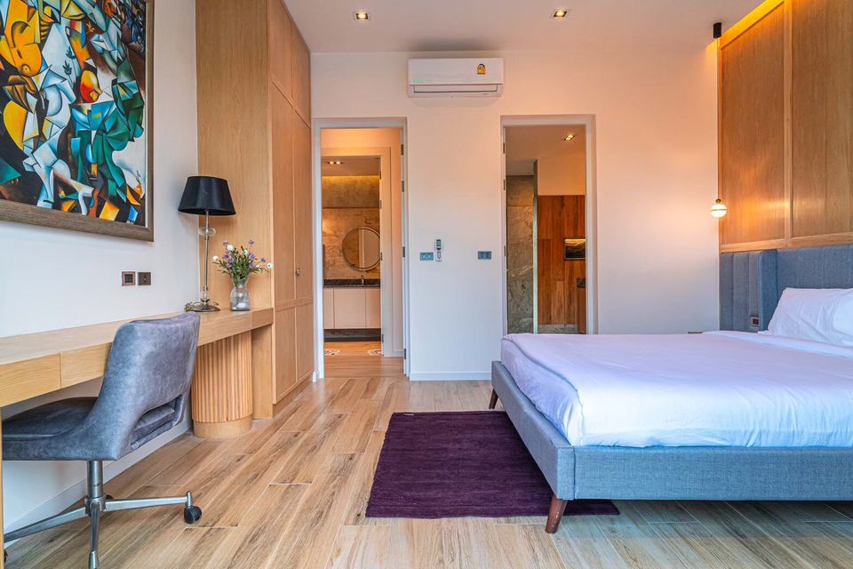 Spacious bedroom at Sea Moment IV Pool Villa, Rayong, featuring a comfortable king-size bed and a dedicated work desk.