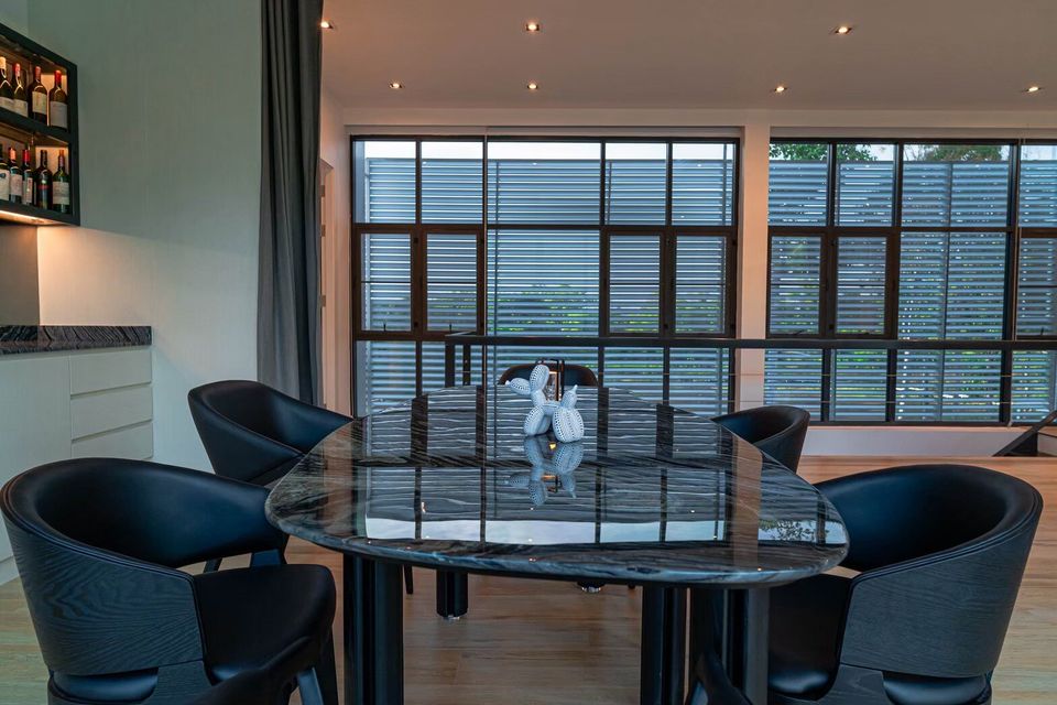 Elegant marble dining table with black chairs and a unique centerpiece at Sea Moment IV Pool Villa, Rayong.