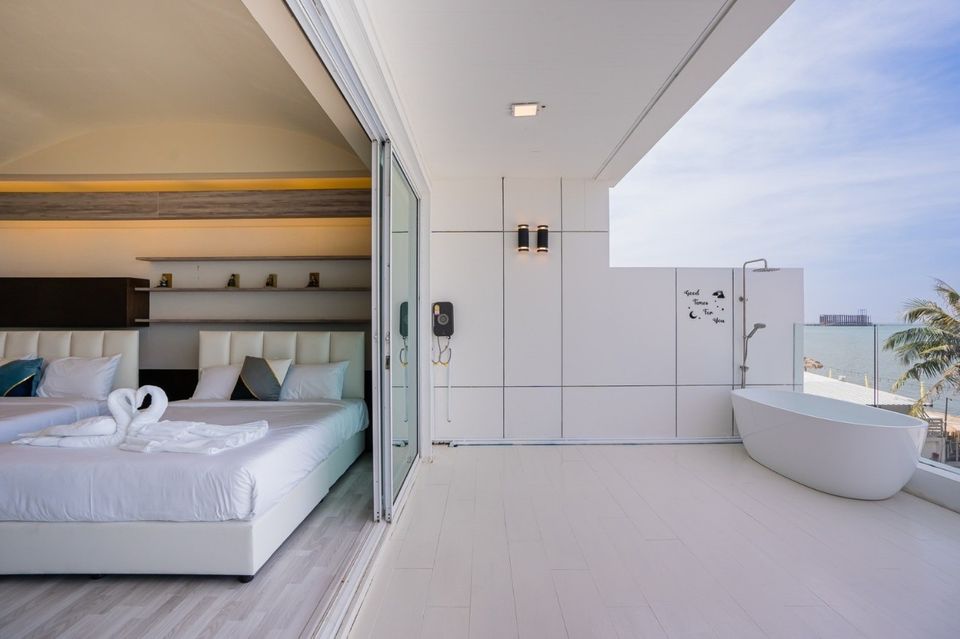 Sea View IV Pool Villa balcony with bathtub and bedroom view, พัทยาเหนือ- บางละมุง. Enjoy outdoor bathing with a sea view.